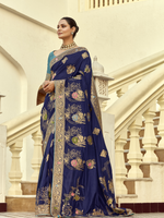Woman wearing a blue saree with floral patterns in an architectural setting