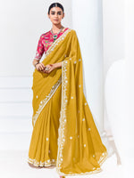 Woman wearing a yellow saree with white border on a white background