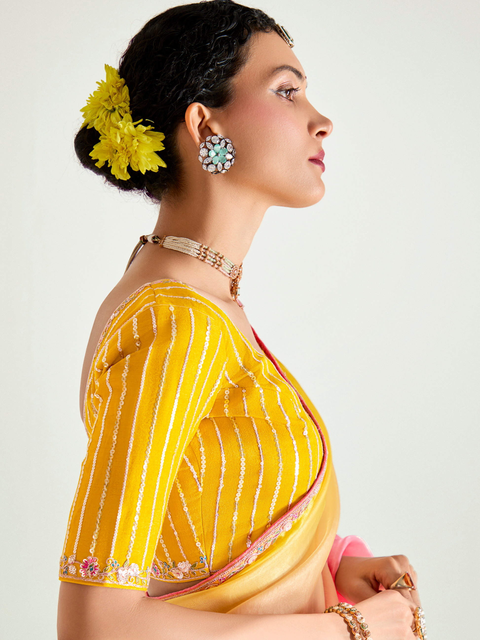 Woman wearing a yellow saree with a white background