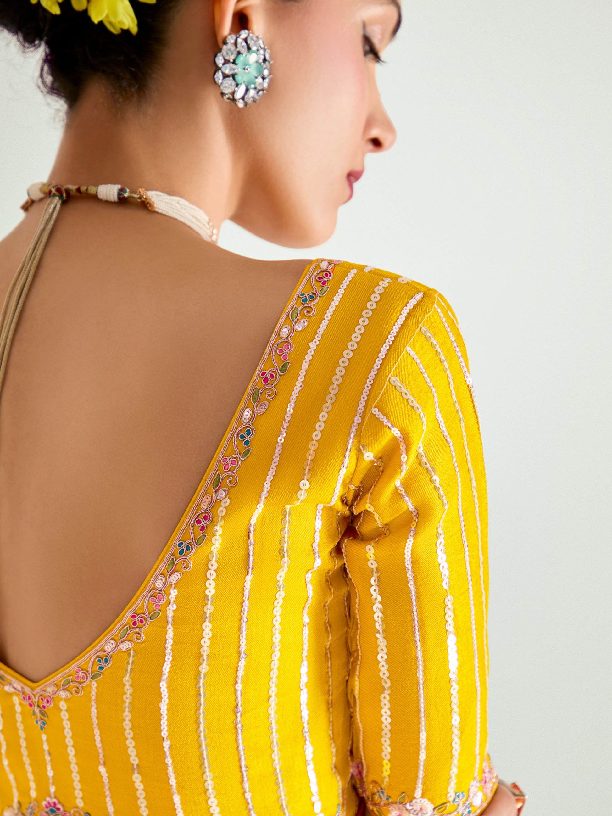 Yellow traditional outfit with floral patterns on a plain background