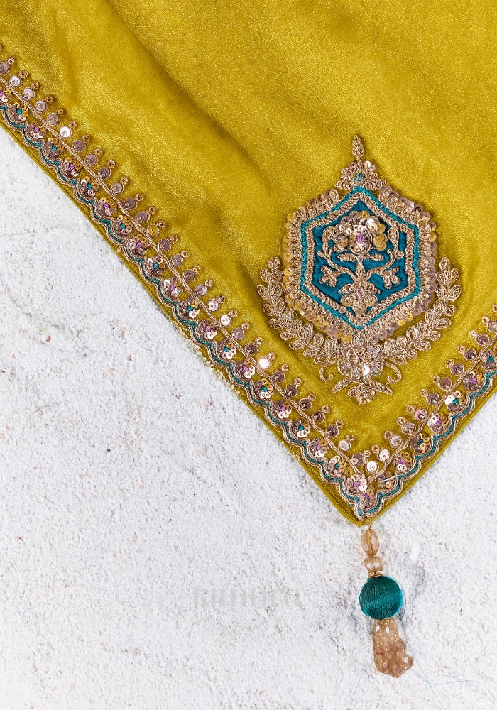 Close-up of the chartreuse yellow saree showcasing intricate zari, sequins and bead embroidered border with elegant craftsmanship.