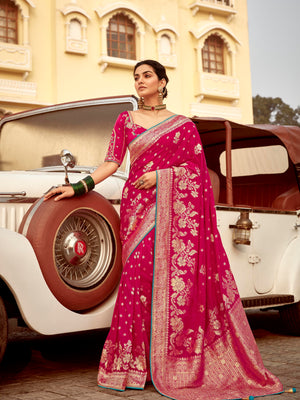 Woman in a pink saree standing next to a vintage car
