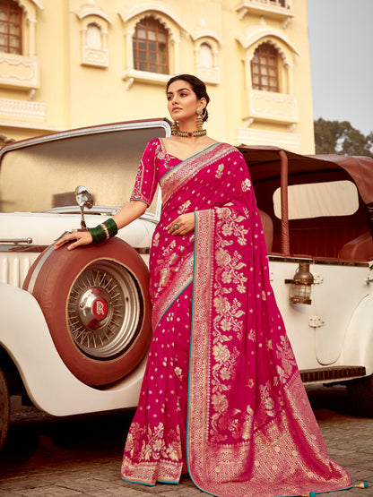 Woman in a pink saree standing next to a vintage car