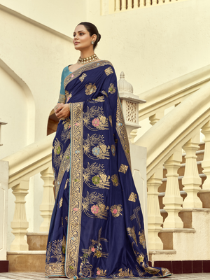 Woman wearing a blue saree with floral patterns in an architectural setting