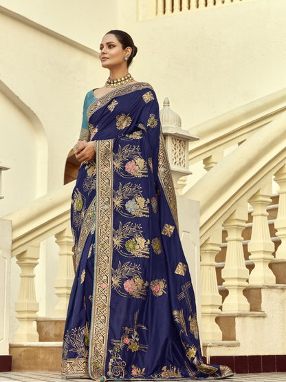 Woman wearing a blue saree with floral patterns in an architectural setting