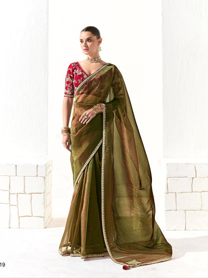 Woman wearing a green saree with a red blouse against a white background, branded 'Kimora'.