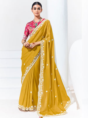 Woman wearing a yellow saree with white border on a white background