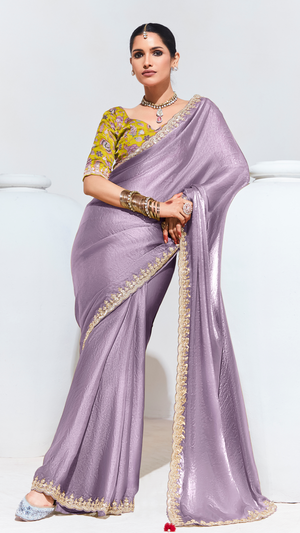 Woman wearing a lavender saree with gold border on a white background