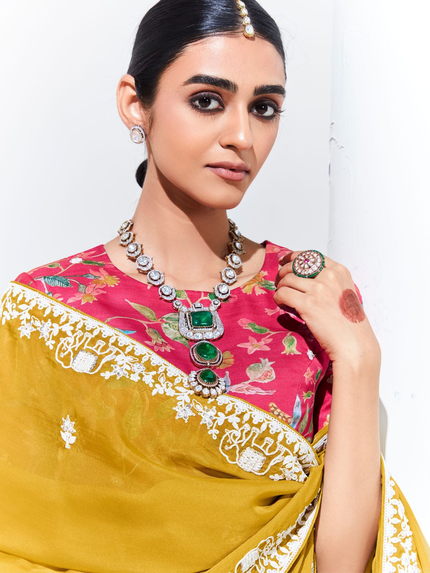 Woman wearing a traditional saree with jewelry against a white background