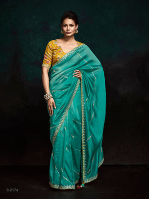 TEAL DESIGNER ORGANZA SAREE WITH HANDCRAFTED EMBROIDERED BORDER – BOLD, ELEGANT, UNFORGETTABLETeal Green Designer Organza Silk Saree