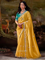 Woman in a yellow saree with a green blouse against a nature-themed backdrop