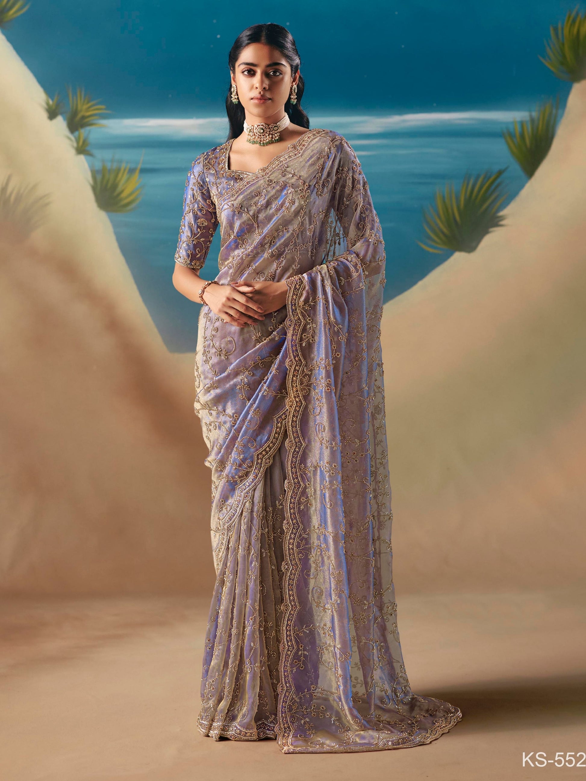 Woman in a saree standing against a scenic desert backdrop