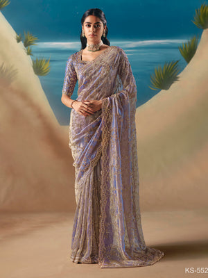 Woman in a saree standing against a scenic desert backdrop
