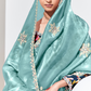 Woman wearing a light blue saree with floral embroidery on a white background
