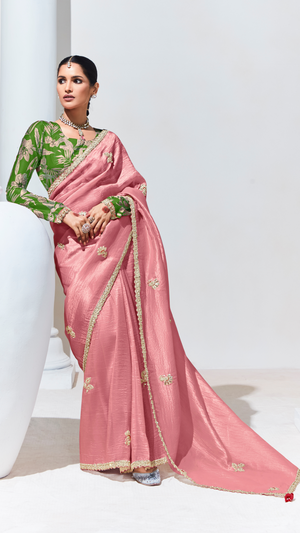Woman wearing a pink saree with green blouse on a white background
