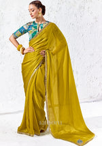Chartreuse yellow Soft Shimmer Tissue Silk saree with zari, sequins and bead embroidery paired with a teal digitally printed satin silk blouse by Kimora.