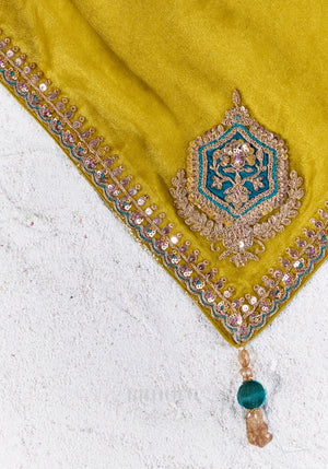Close-up of the chartreuse yellow saree showcasing intricate zari, sequins and bead embroidered border with elegant craftsmanship.