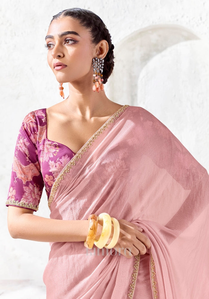Designer blush pink Tissue Silk saree featuring an embroidered gold border and magenta floral printed blouse for weddings and festive occasions.
