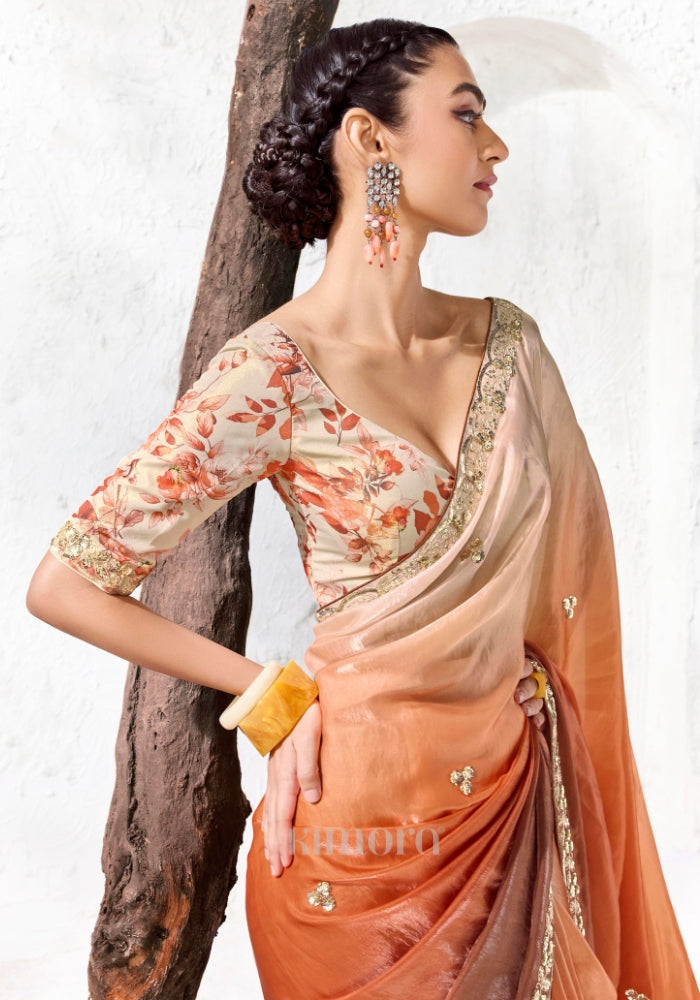 Designer ivory and burnt orange ombre tissue silk saree featuring an embroidered floral border and digitally printed satin silk blouse.