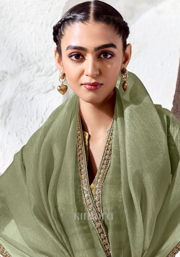 Elegant sage green Tissue Silk saree with gold bead tassels, embroidered border and printed blouse, perfect for weddings, receptions and festive celebrations.