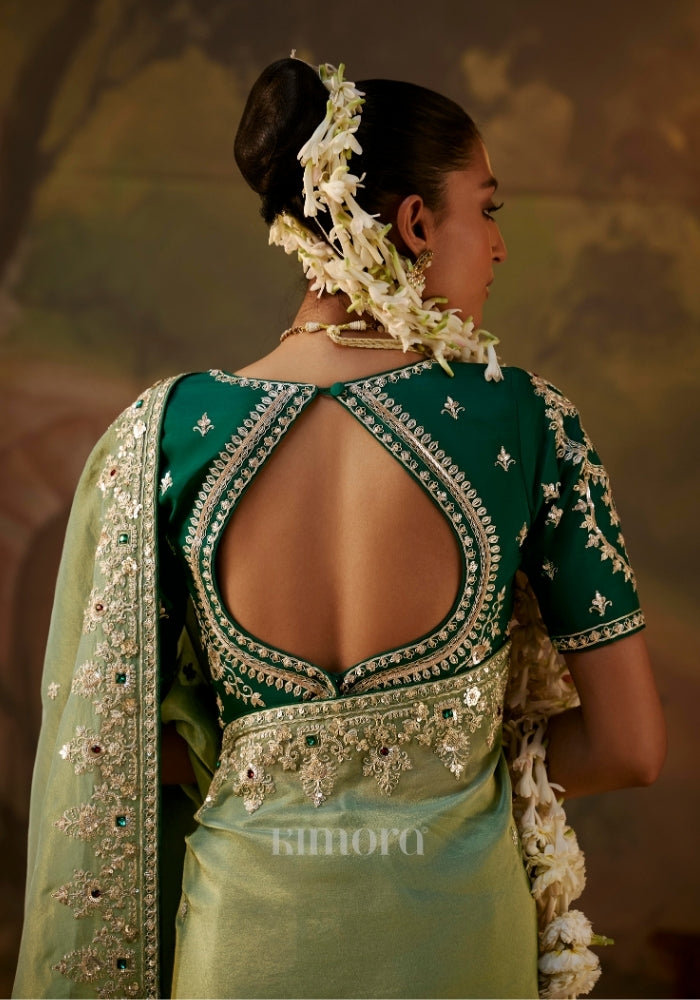Back view of a woman wearing a dark green embroidered blouse