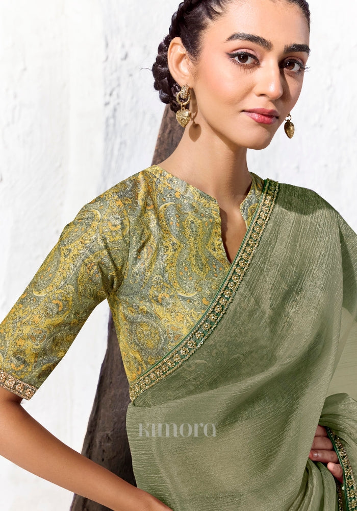 Green and gold digitally printed satin silk blouse with paisley print paired with a premium sage green embroidered Tissue Silk saree.