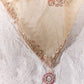 Model wearing a designer champagne gold Mulberry Cotton Silk saree featuring floral zari embroidery, sequin detailing and a contrasting red printed blouse.