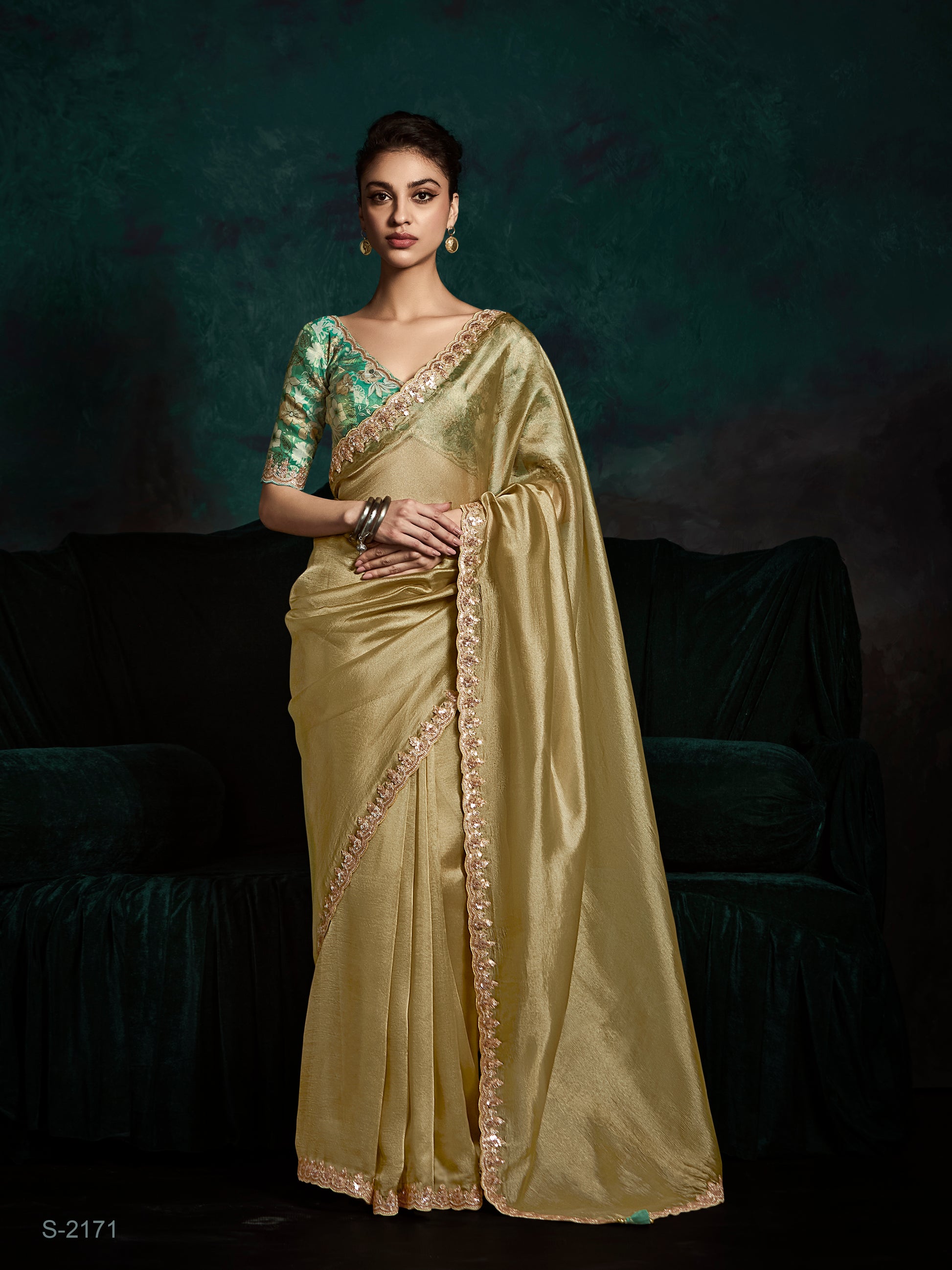 Woman wearing a light green saree with a dark background