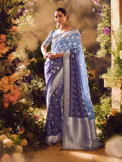Woman in a blue saree standing in front of a floral archway