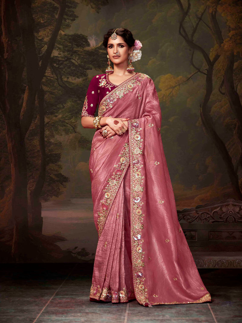 Woman in a traditional pink saree with a dark background