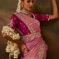 Woman wearing a pink embroidered silk saree with a magenta blouse, traditional 