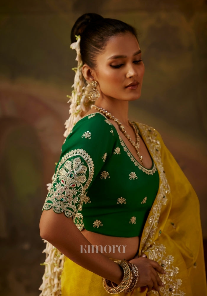 Back view of a woman in an intricately embroidered green blouse  