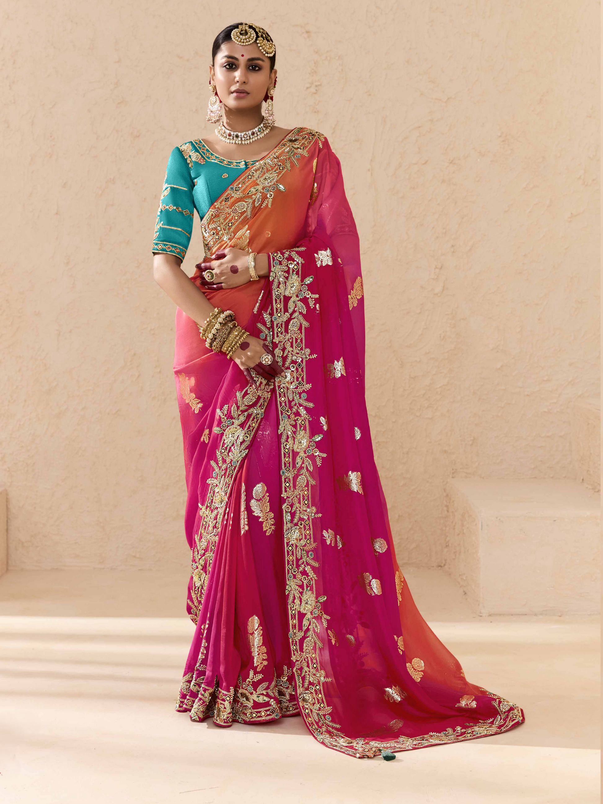 Woman wearing a traditional saree with intricate designs on a neutral background